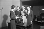 Women Standing Around a Table 01