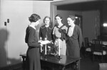 Women Standing Around a Table 02